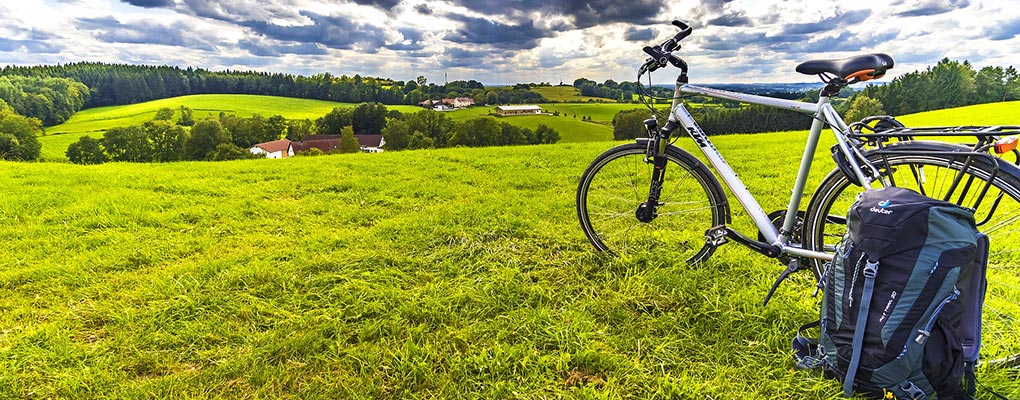 Rast auf einem Feld mit Rad und Rucksack; FelixMittermeier von Pixabay